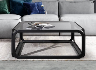 Rectangular coffee table made of glass with modern wooden frame in living room